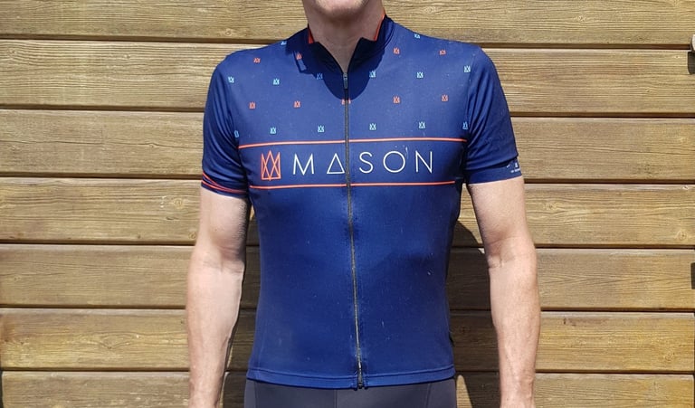 Front of the navy Mason X Morvelo summer jersey, with orange stripes and Mason lettering across the chest.