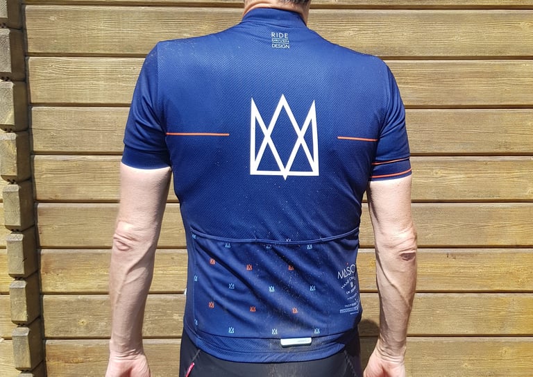 Back of the navy Mason X Morvelo summer jersey, with a large white crown logo and rear pockets.