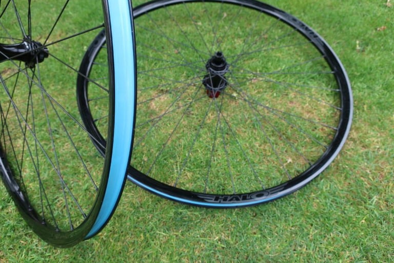 Halo Vapour GXC wheels on grass, showing the blue tubeless tape inside the rims and a red freehub.