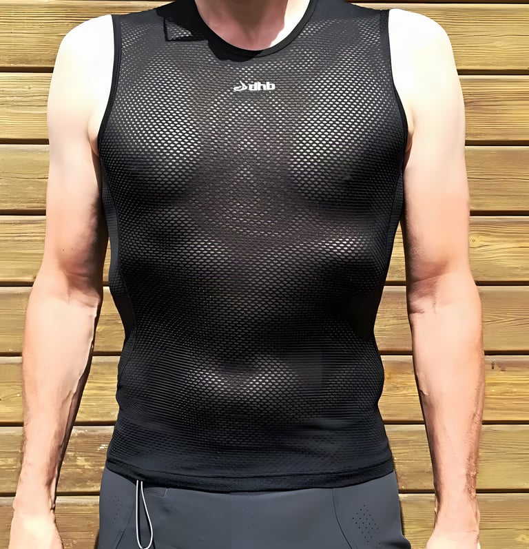dhb Lightweight Mesh sleeveless base layer in black, worn by a rider in front of a wooden fence.