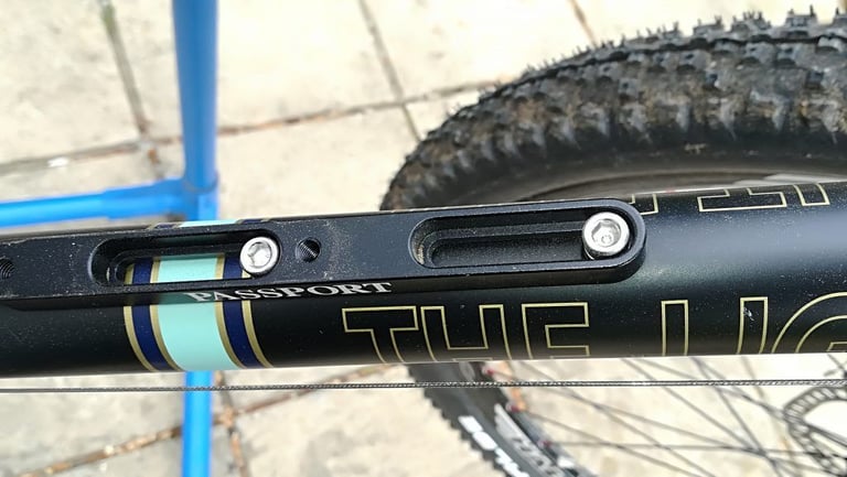 Cage Mover bottle cage adjuster with slotted mounting bolts on the down tube of the Light Blue Darwin One By MT.