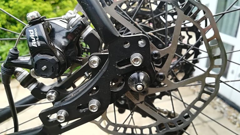 Close-up of the Darwin's ADS-3 rear dropout with an Avid BB7 disc brake caliper and slotted adjuster plate.