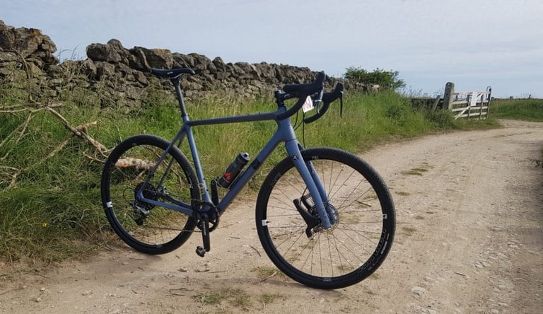 Lauf True Grit with its leaf-spring fork parked beside a drystone wall on a gravel track on the Yorkshire Moors.