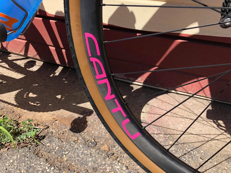 Pink Cantu logo on a black carbon gravel rim with a tan-wall Panaracer Gravel King tyre on Paul Errington's Warbird.