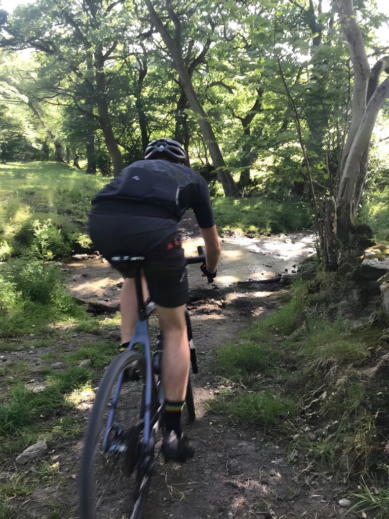 Rider on the Lauf True Grit heads down a shaded woodland track towards a ford at Yorkshire True Grit.