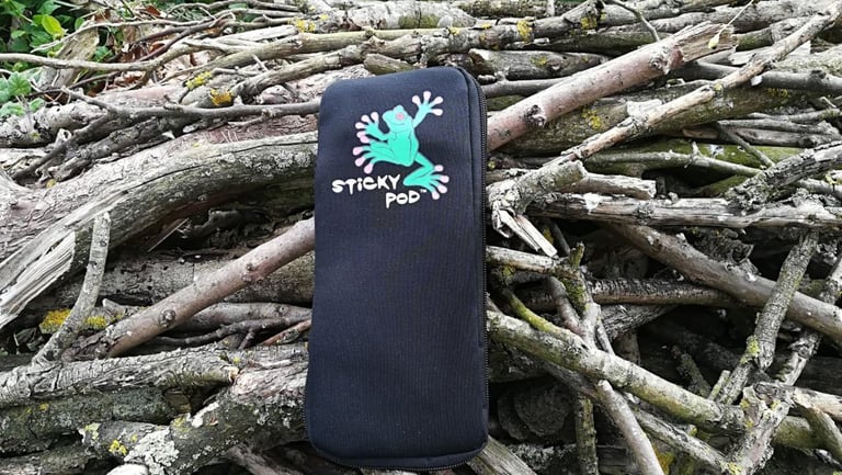Large Sticky Pod zip pouch, closed, photographed from above on a heap of dead branches.