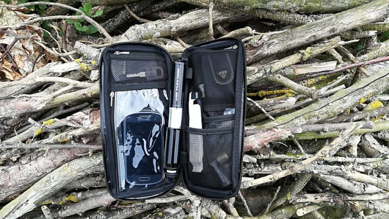 Open Large Sticky Pod with a phone behind its clear window, a mini pump in the centre and tools in the mesh pockets.