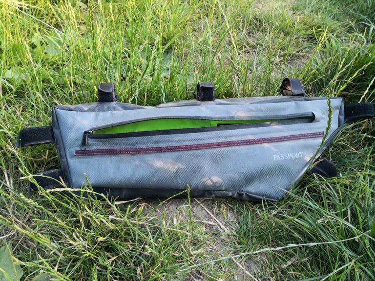 Passport Large frame bag in grey with a lime-green liner showing through its open side zip.