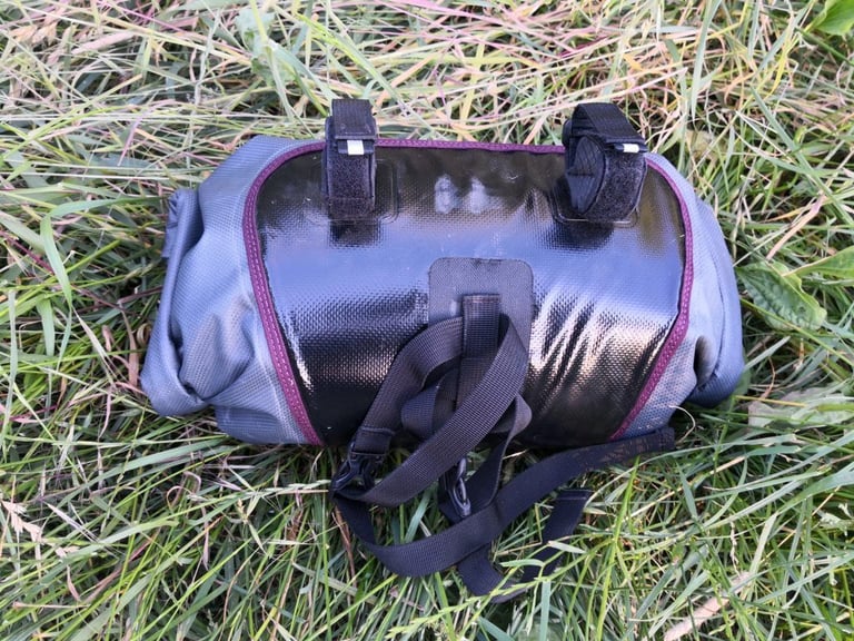 Rear of the Passport handlebar bag with its black tarpaulin contact panel, two Velcro bar straps and buckled straps.