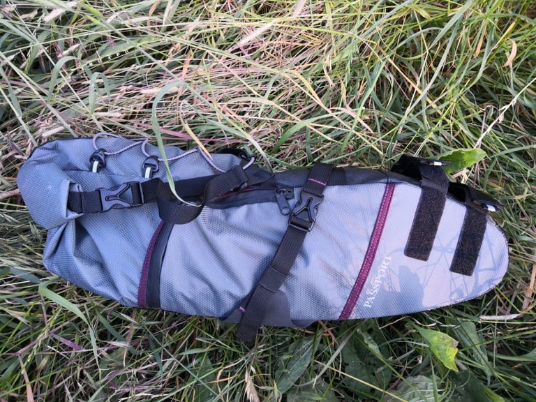 Passport seat pack side view showing the logo, purple trim, roll closure and rubberised seatpost straps.