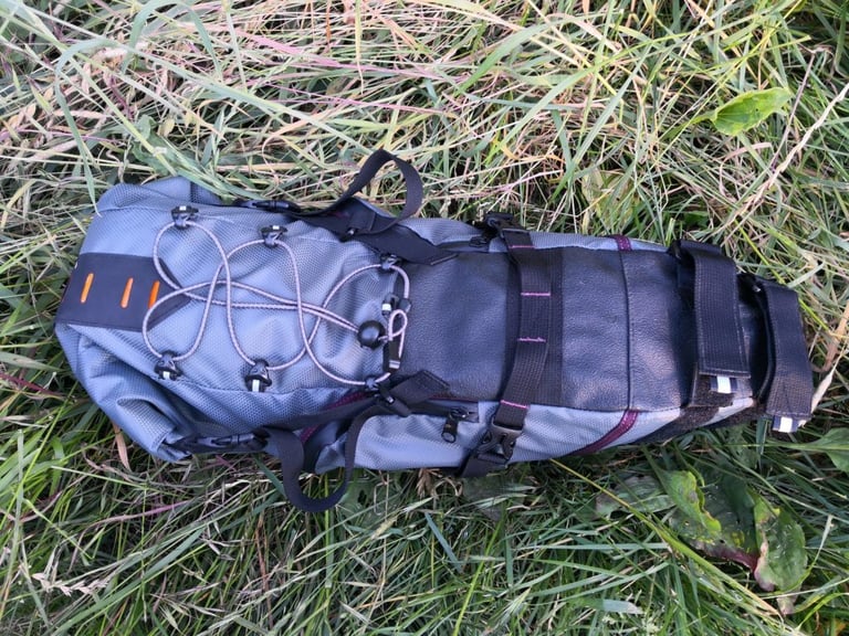 Passport Large seat pack, top view, in grey with bungee cord, buckles and reflective tabs.
