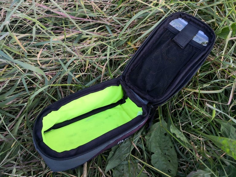 Passport top-tube bag opened to show its bright lime-green liner and mesh pocket in the lid.