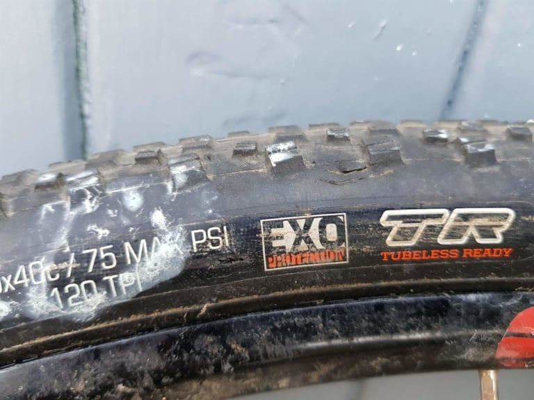 Dirty Maxxis Rambler sidewall splattered with dried sealant, marked EXO Protection, 120 TPI and Tubeless Ready.