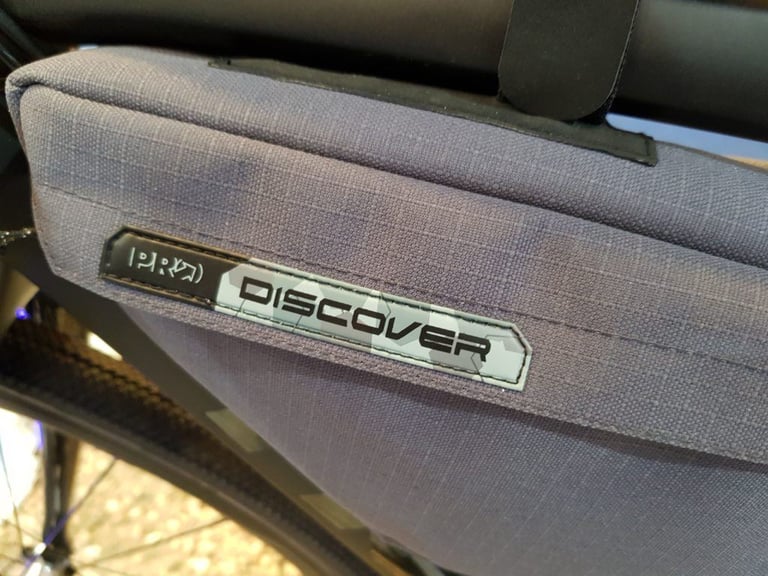 Close-up of the PRO Discover logo on a grey bikepacking frame bag.