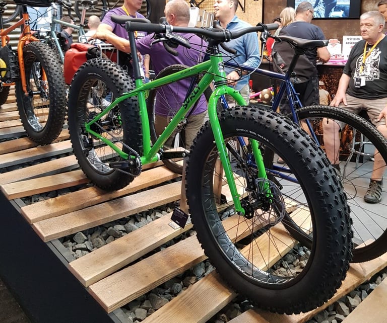 Green Surly Ice Cream Truck fat bike with huge knobbly tyres on a wooden-slat display at Surly World, Eurobike 2018.