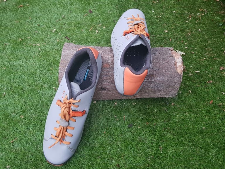Pair of Shimano XC5 shoes seen from above, with the orange heel counter and reflective rear visible.