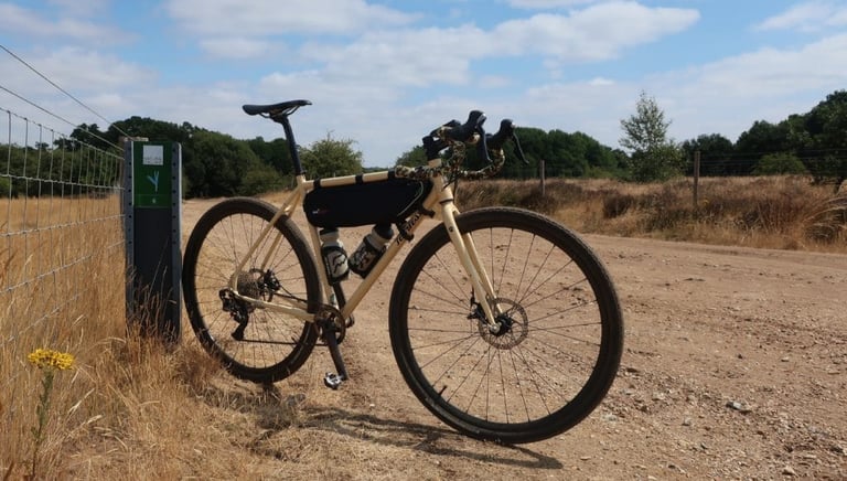 Fearless Vulture with camo bar tape leans on a fence post beside a dry gravel track in the summer of 2018.