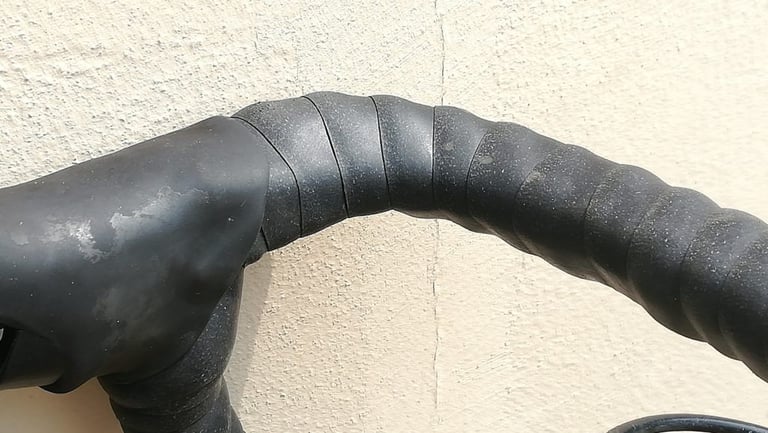 Close-up of Genetic silicone tape wound around a drop bar beside the brake hood, showing the overlapping wraps.