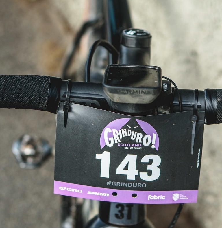 Grinduro Scotland number board 143 cable-tied to the handlebars of the 3T Exploro, with a Garmin computer.