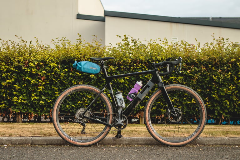 3T Exploro with Ortlieb saddle bag and two bottles parked on the kerb in front of a hedge before Grinduro.