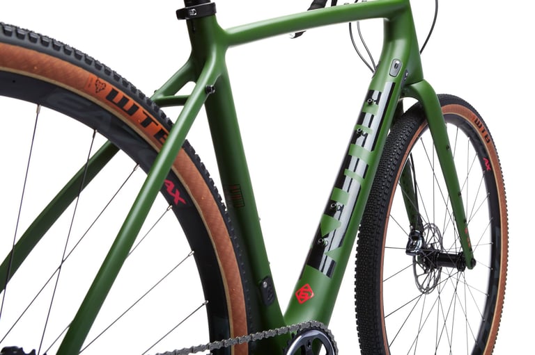 Kona Libre DL in matt green, close-up of the frame and front wheel with tan-wall WTB gravel tyres.