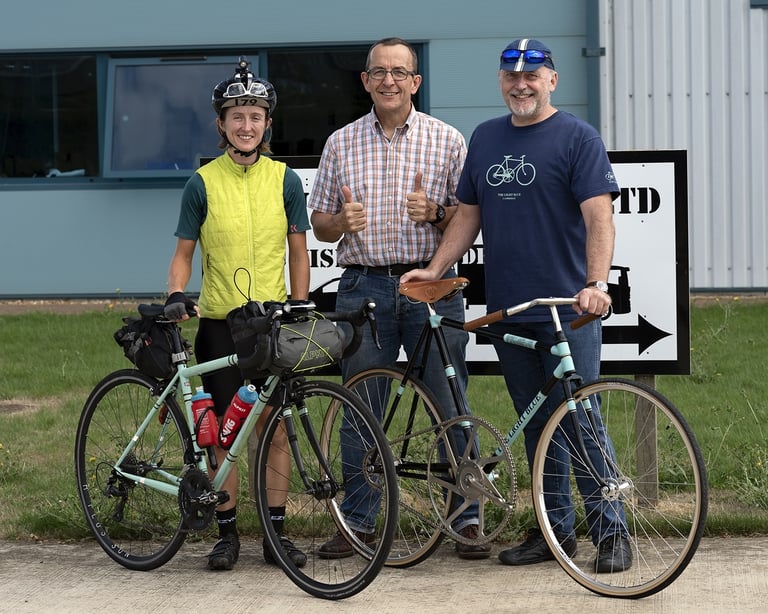 Ede Harrison stands with Steve Clarke and Lloyd Townsend outside The Light Blue HQ, her Wolfson and a second bike in front.