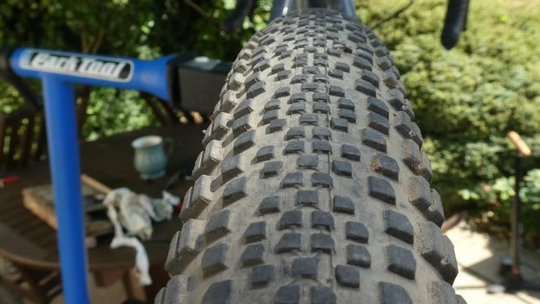 WTB Riddler 700 x 45c tread from above, small central knobs flanked by bigger shoulder knobs, bike in a workstand.