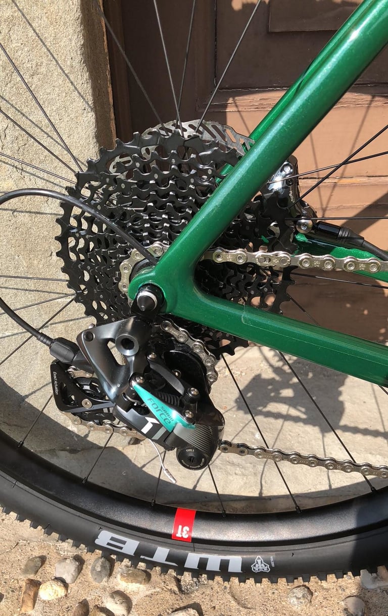 SRAM Force rear mech and wide-range cassette on the green 3T Exploro Flatmount, above a WTB tyre.