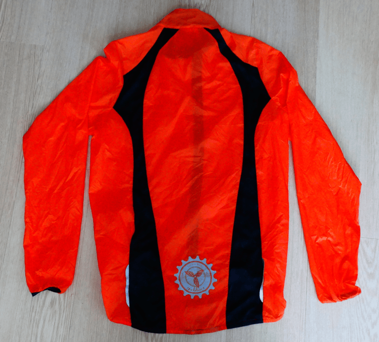 Back of the orange Galibier VentUltra jacket, with black panels, reflective logo and reflective strips.
