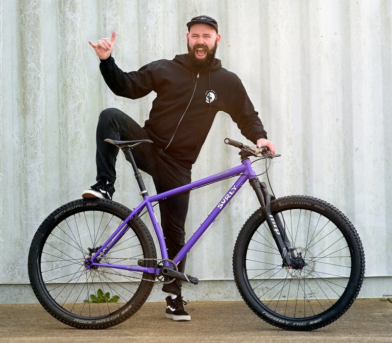 Duncan of Ison Distribution poses with his purple Surly Karate Monkey single-speed mountain bike.