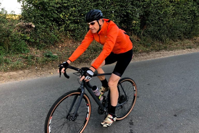 Rider on a drop-bar bike in the Galibier VentUltra jacket, seen from the front on a quiet lane.