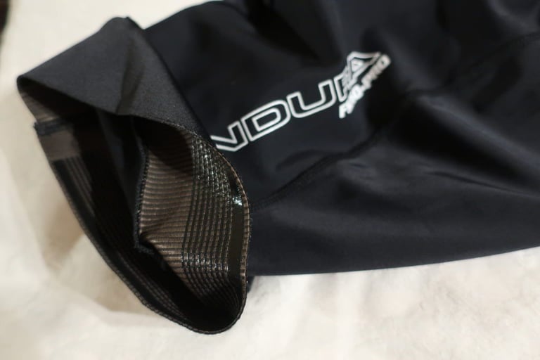 Wide silicone leg gripper inside the hem of Endura FS260-Pro bibshorts, beside the white printed logo.