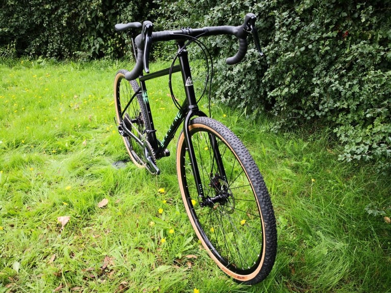 Front three-quarter view of the Marin Four Corners with flared drop bars and 42c WTB tyres on a lawn.