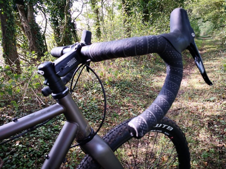Redshift ShockStop stem and black drop bars on a bike, on a leafy off-road track.