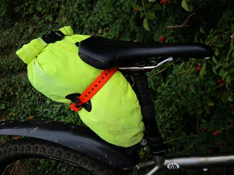 Orange Voile strap holding a tapered dry bag under the saddle as a seat pack alternative.
