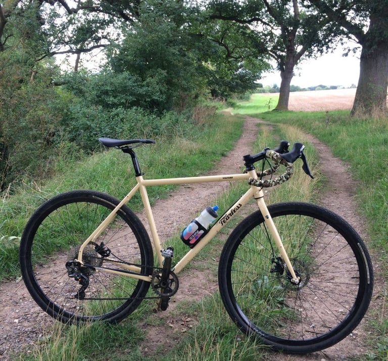 Fearless Vulture parked on a grassy double track beside a field, framed by oak trees.