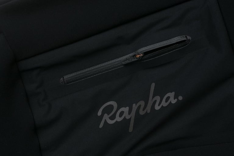 Rapha cargo winter tights in black, close-up of the zipped thigh pocket and reflective logo.