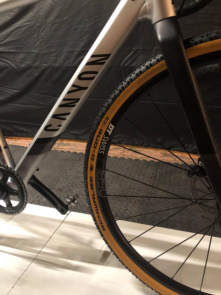Close-up of the Canyon Grail AL down tube logo and front DT Swiss rim with a Schwalbe G-One tyre.