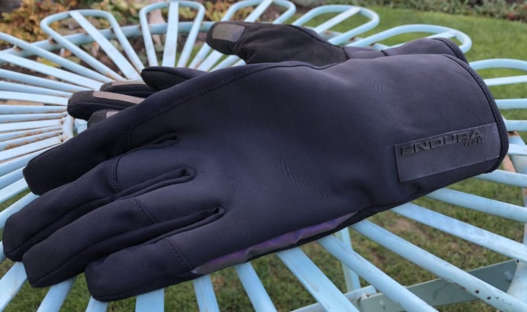Back of the black Endura Pro SL Primaloft glove on a garden chair, with the logo patch and long cuff.