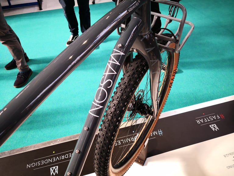 Mason lettering on the grey ISO fork, with a front rack and a tan-wall knobbly tyre.