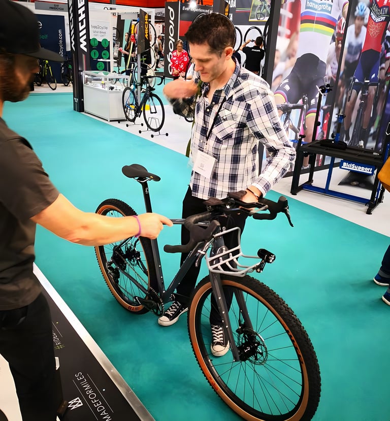 Visitor looks over the grey Mason ISO with front rack, dynamo light and tan-wall tyres at the Cycle Show.