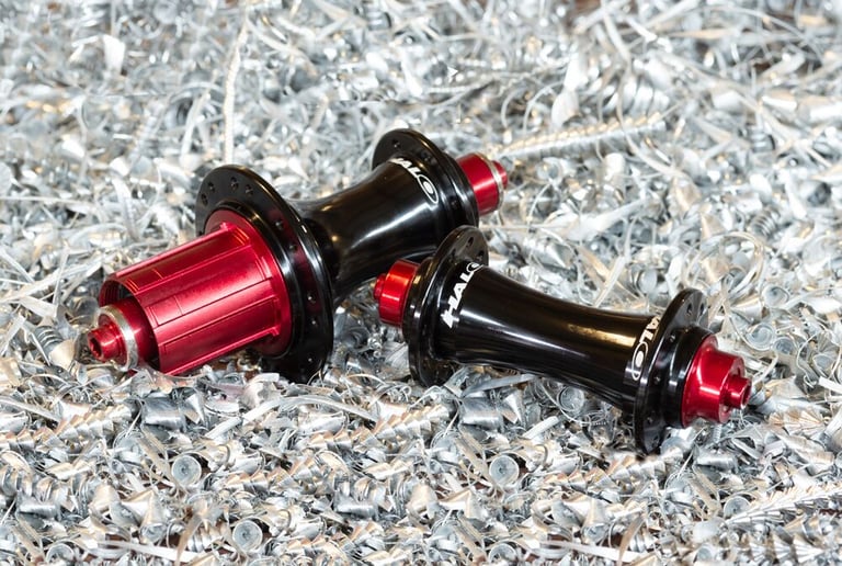 Halo Carbaura RC road hubs in black with red freehub and end caps, front and rear, resting on metal swarf.
