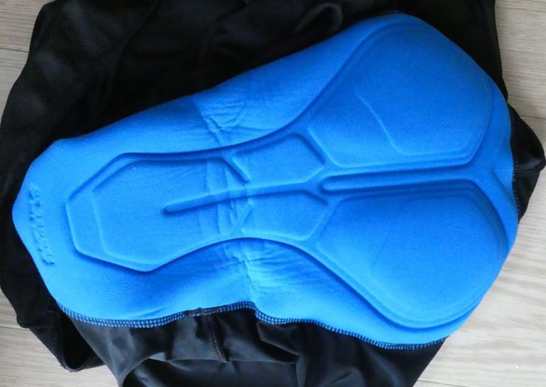 Blue chamois pad inside the Altura Repel Bibtights, laid flat on a wooden floor.