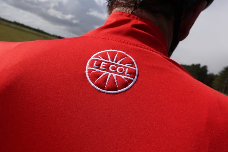 Le Col logo embroidered on the back of a red Therma Jersey.