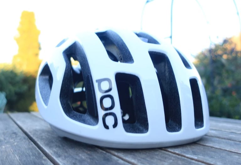 White POC Octal helmet on a garden table, front three-quarter view, showing its many vents.
