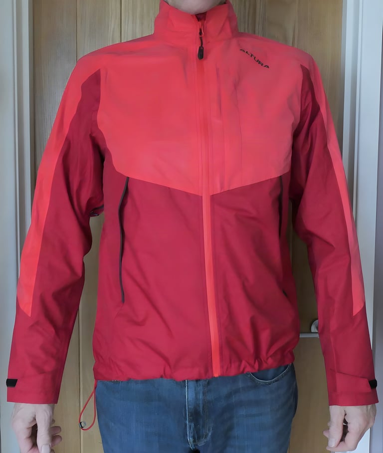 Front view of the red Altura Nightvision Thunderstorm Jacket worn zipped up, with cuff tabs and a drawcord hem.
