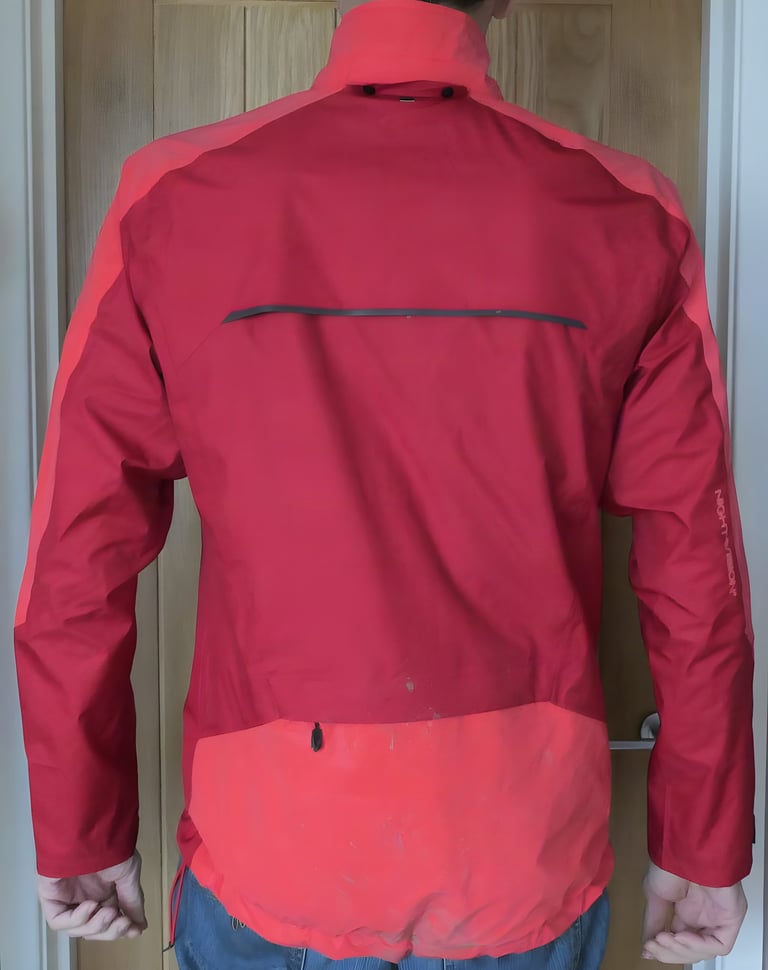 Back of the red Altura Nightvision Thunderstorm Jacket, showing the scooped tail and lighter reflective lower back panel.