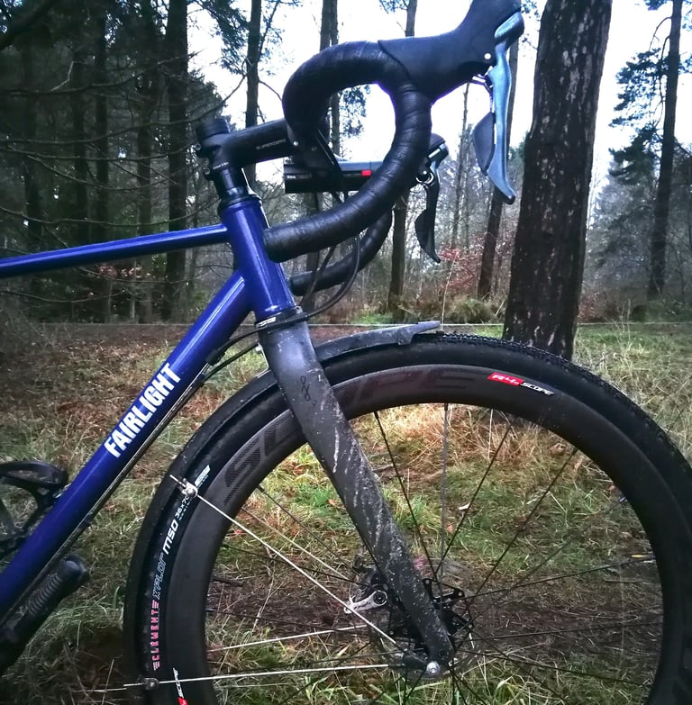 Front of the Fairlight Secan with Scope R4 carbon disc wheel and XPLOR MSO 700 x 36c tyre in woodland.