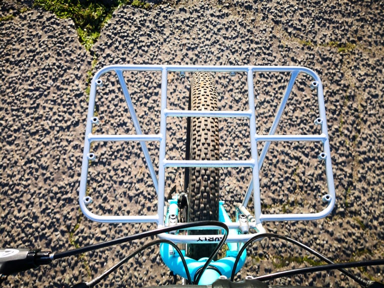 Top view of the Surly 24-Pack Rack over the front tyre, showing the threaded eyelets around its frame.