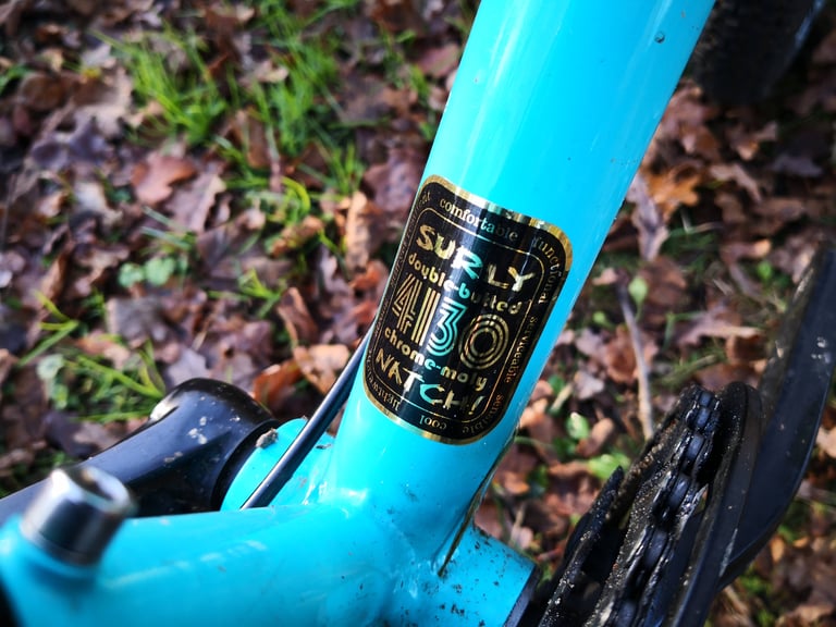 Surly Natch double-butted 4130 chrome-moly decal on the teal Bridge Club frame, just above the bottom bracket.